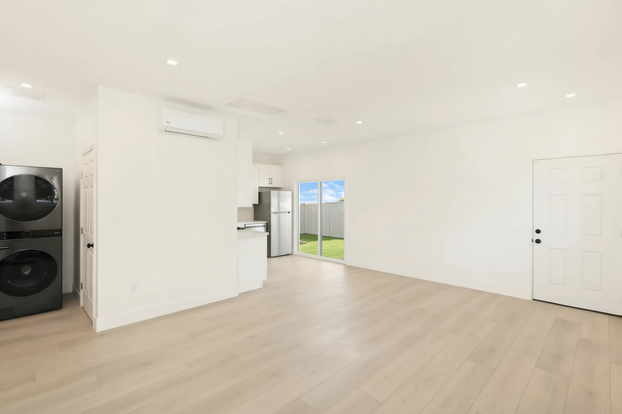 Garage conversion ADU — open living toward the kitchen and stacked laundry, Brea, Avorino