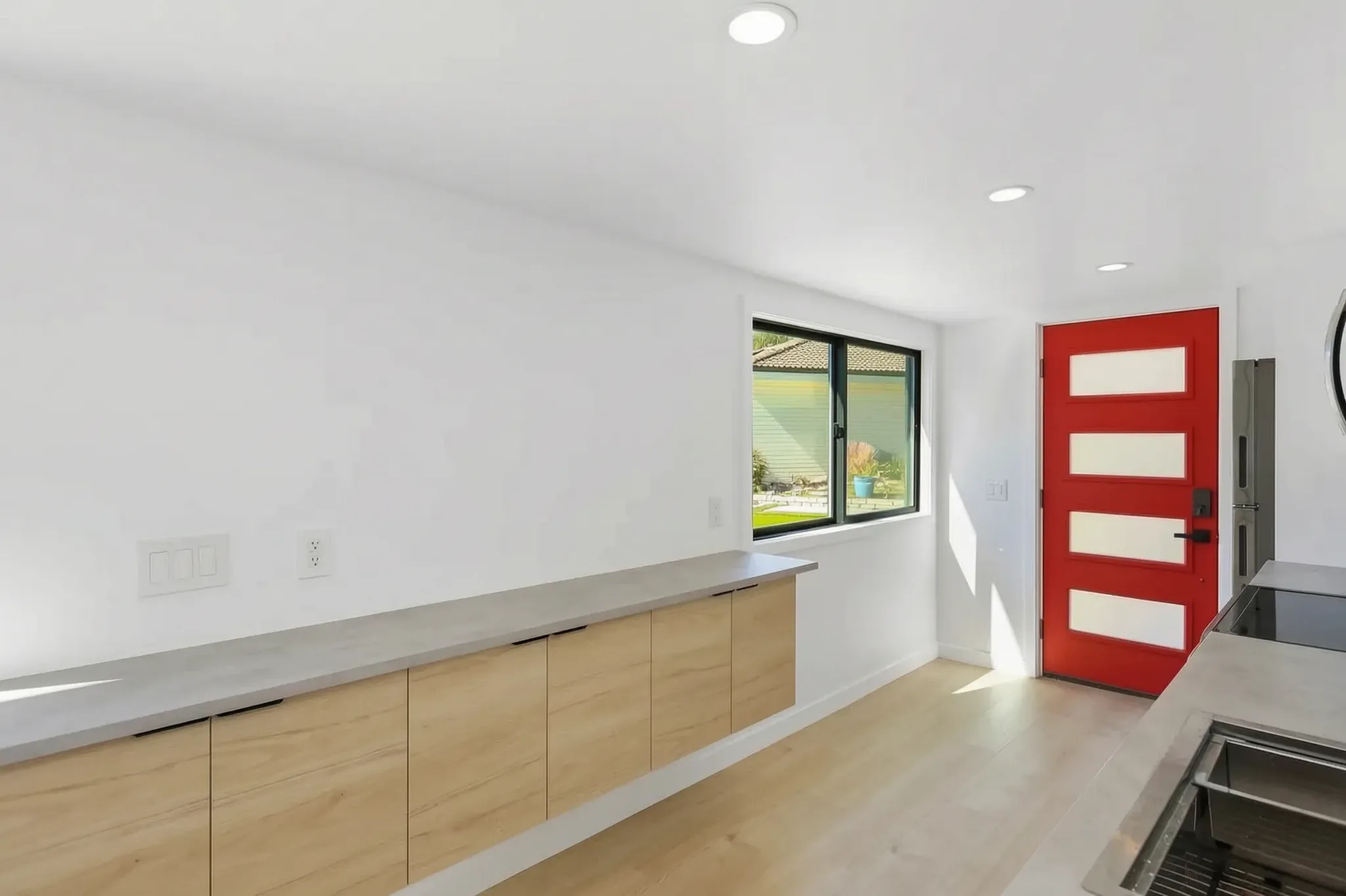 Two-story detached ADU — kitchen counter run and red entry door, Santa Ana Hills, Avorino