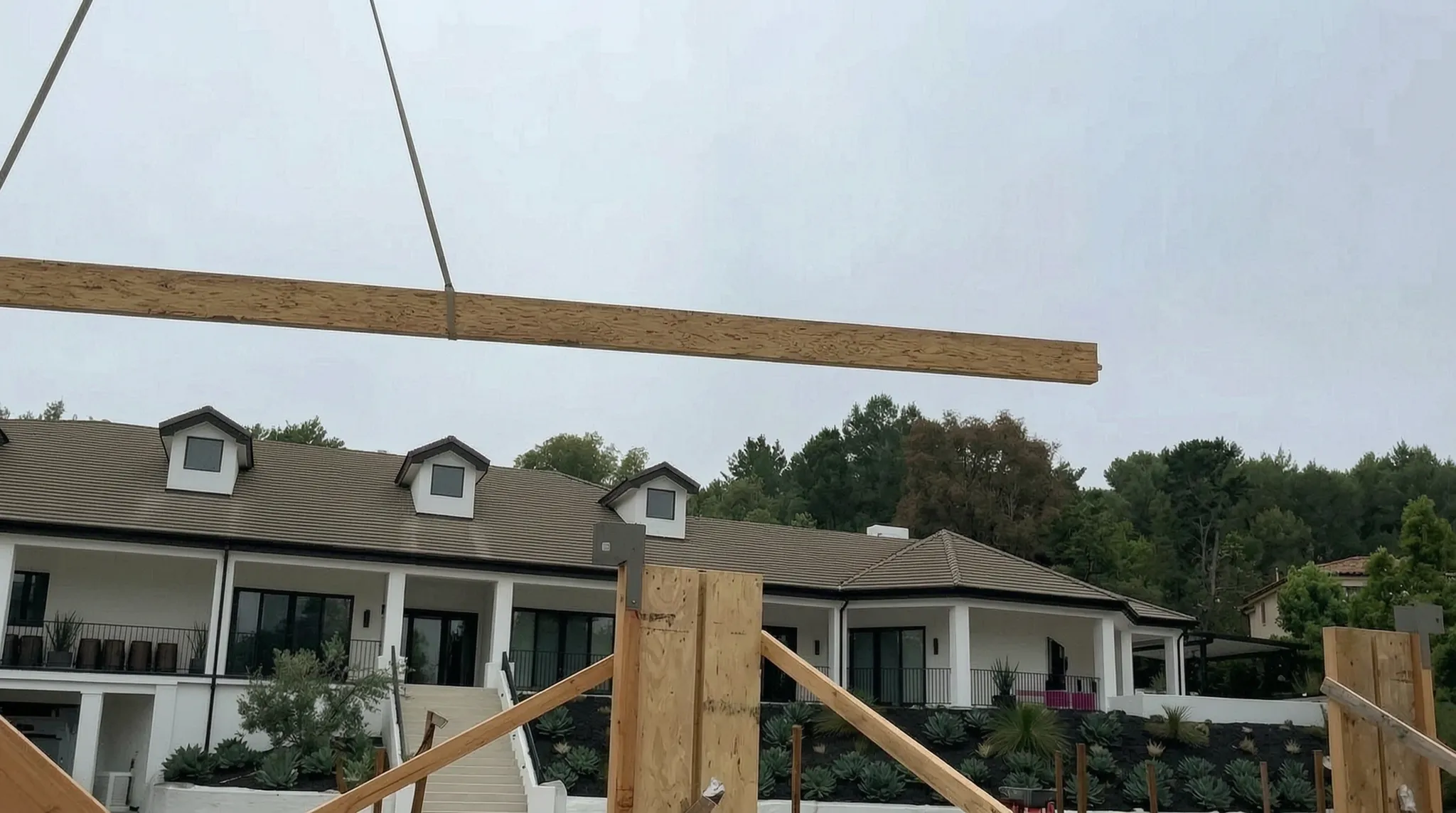 Pool house under construction — glulam ridge beam craned into place, San Juan Capistrano, Avorino