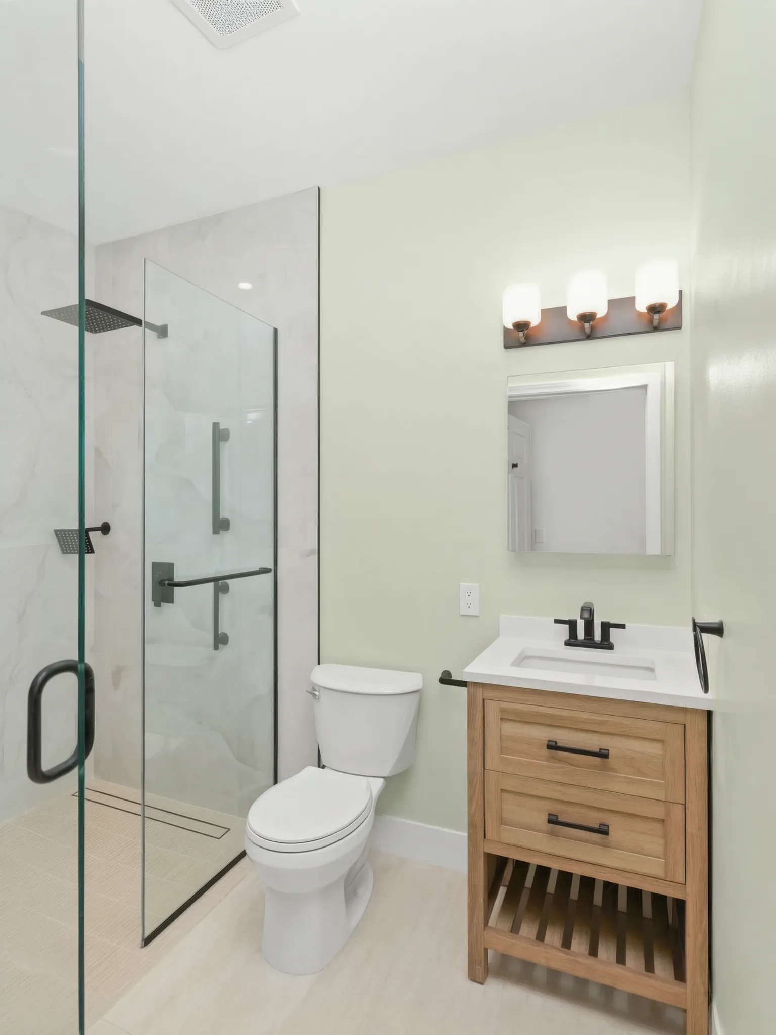 Garage conversion ADU — bath with glass shower and oak vanity, Brea, Avorino