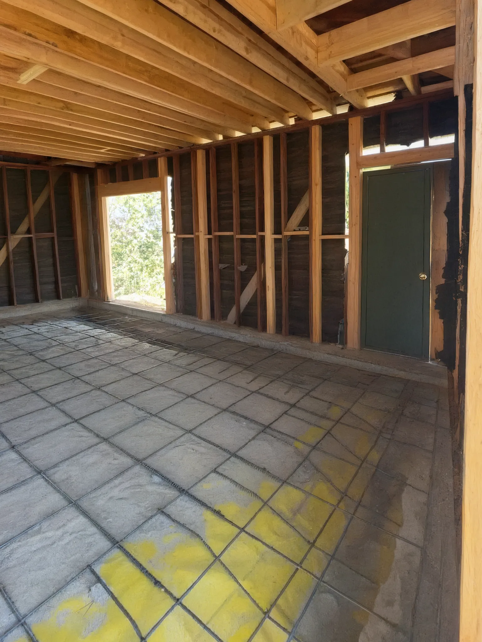 Garage conversion ADU under construction — rebar over the vapor barrier inside the stripped garage shell, Brea, Avorino