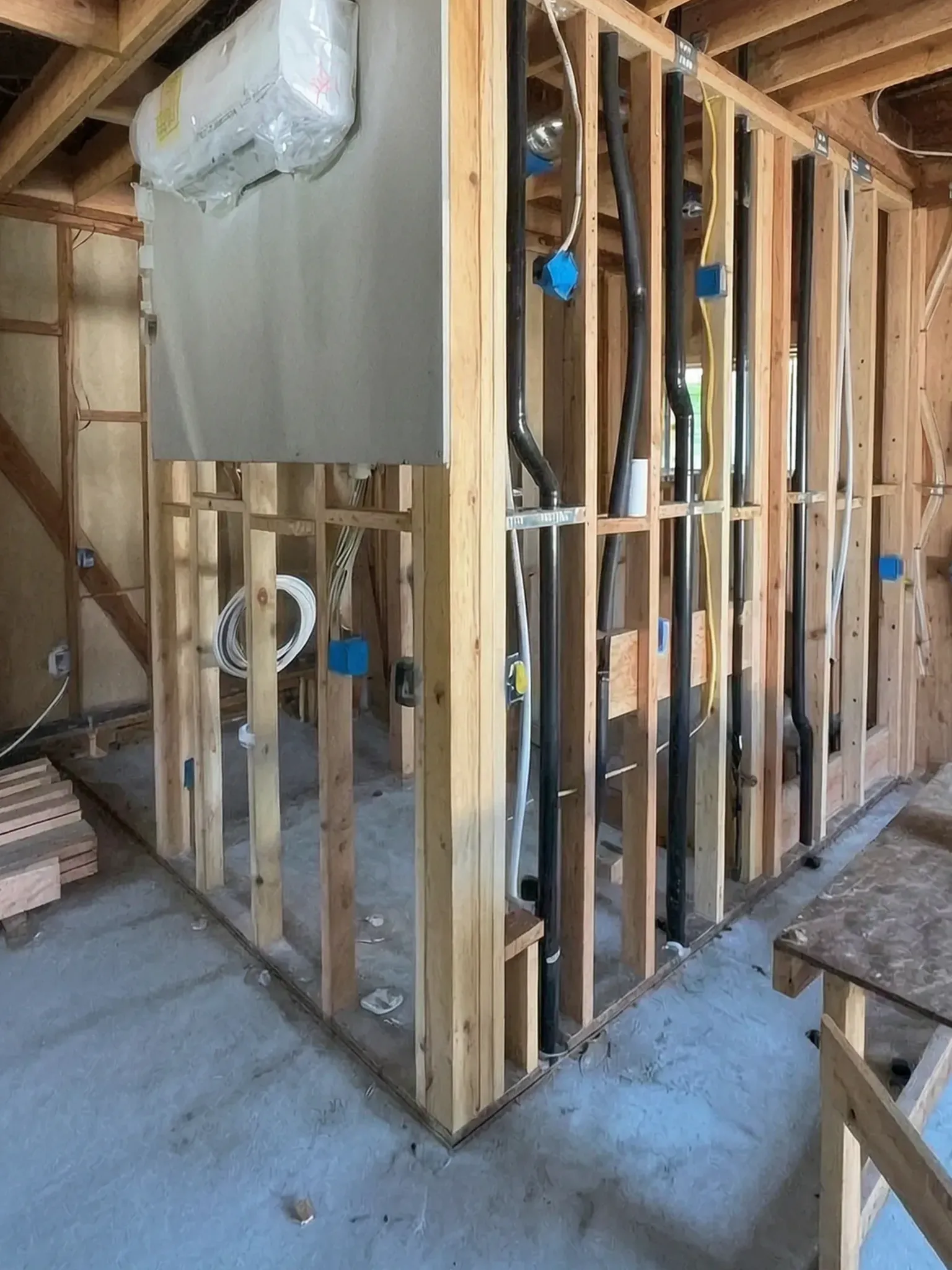 Garage conversion ADU under construction — bathroom partition framing with drain and supply rough-ins, Brea, Avorino