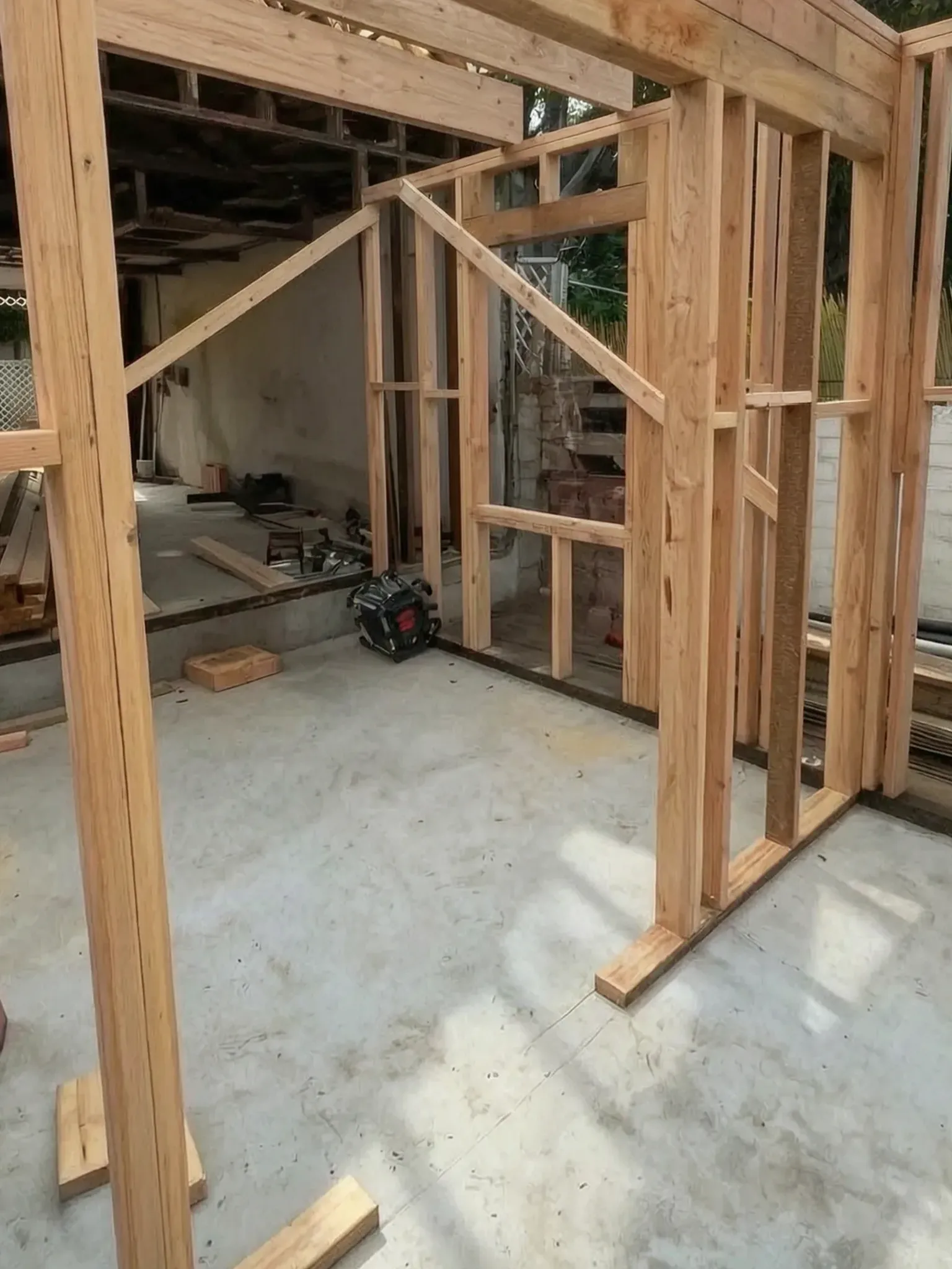Attached ADU under construction — first wall framing and header beam on the new slab, Orange, Avorino
