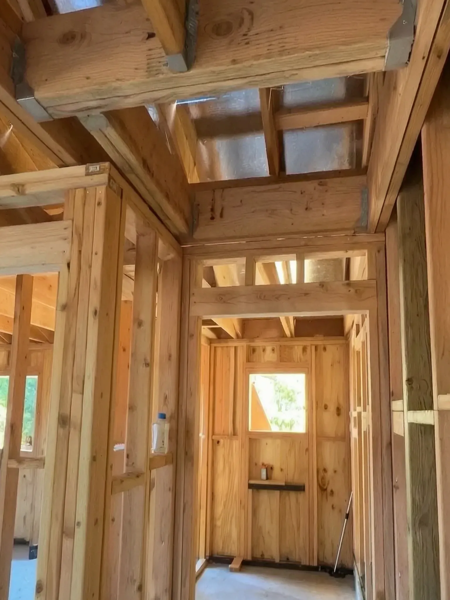 Attached ADU under construction — framed hallway with double headers and ceiling joists, Orange, Avorino