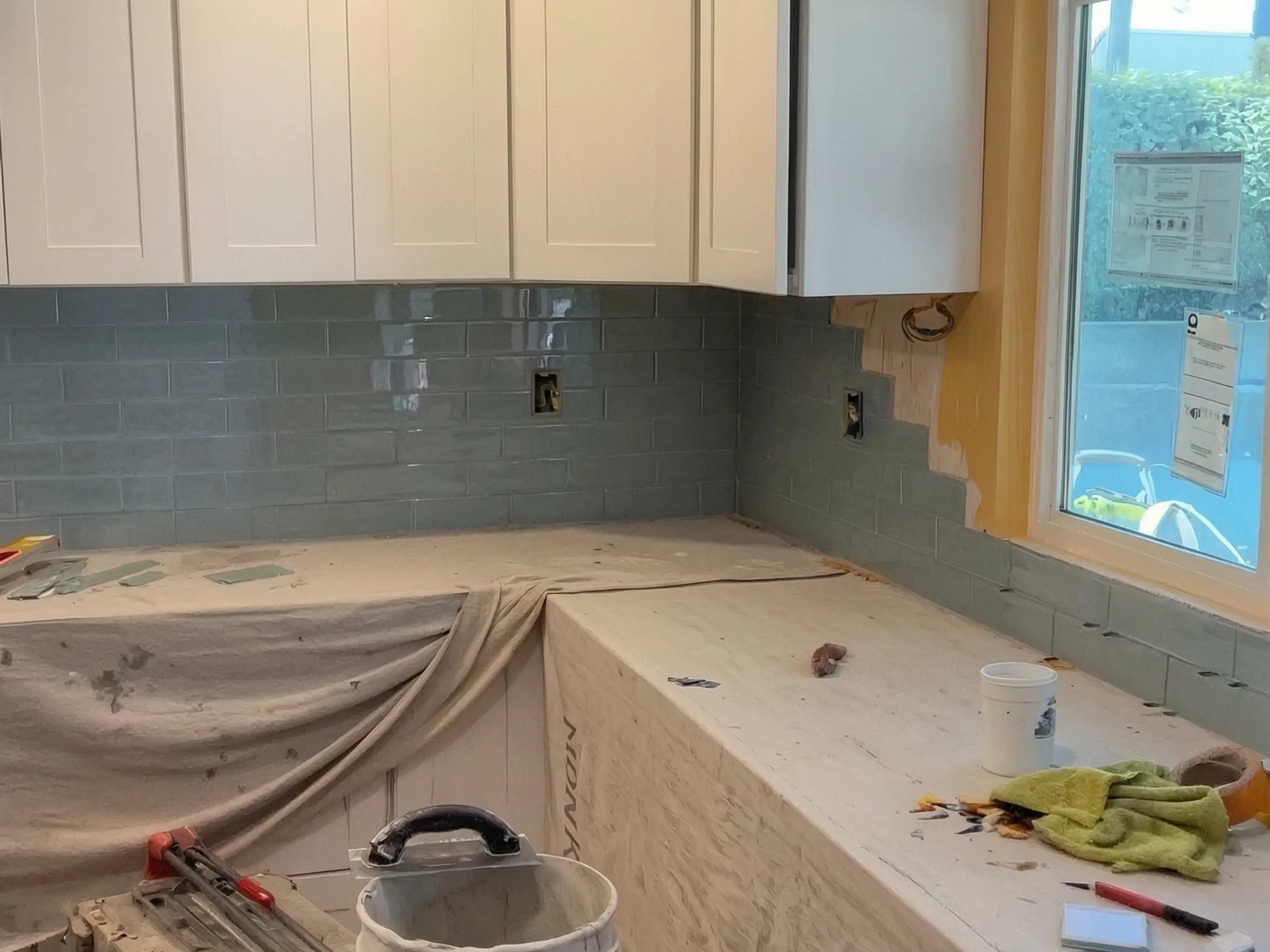 The backsplash going up. Kitchen remodel, Orange, by Avorino.